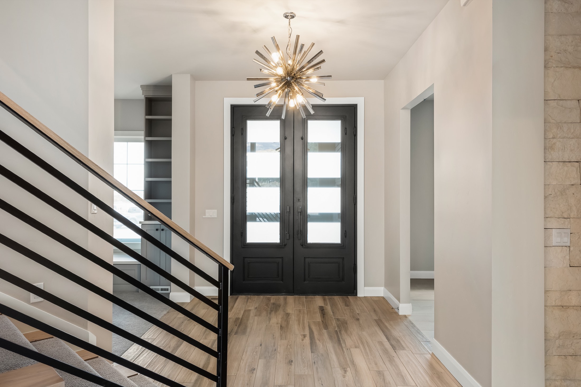Entry foyer with black steel railing and statement lighting