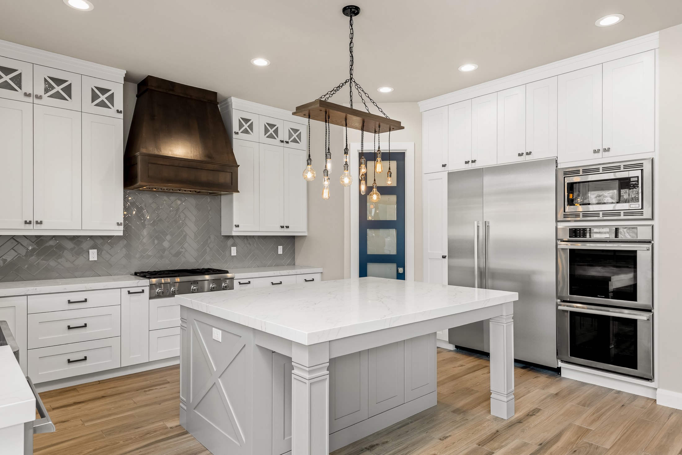Kitchen with grand island and custom range hood